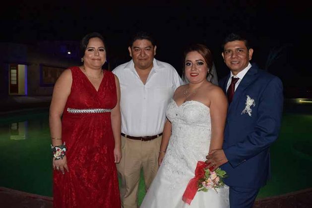 Julio César Pérez y Karina Flores felicitando a los recién casados.